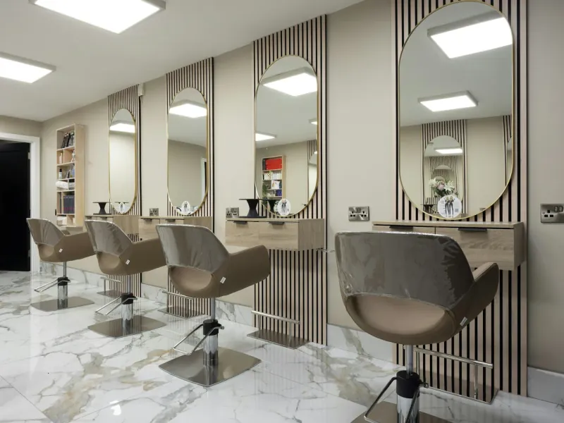 Salon mit beleuchteten Spiegeln an den Arbeitsplätzen