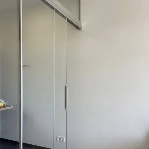 Безрамні розсувні скляні двері між кухнею та вітальнею