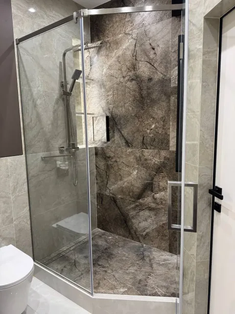 Кутова душова перегородка на сатинових завісах з чорною ручкою під кутом виступу стіни