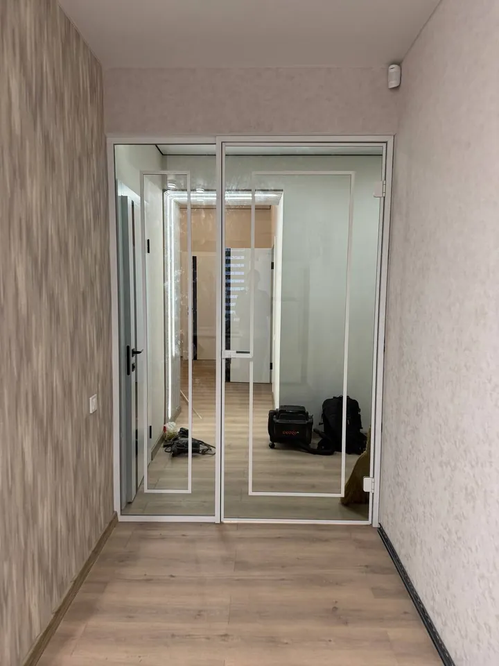 Двері гардеробу зі світлим профілем у кінці коридору
